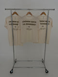 Donde Esta La? Tee — three cream tees on rack