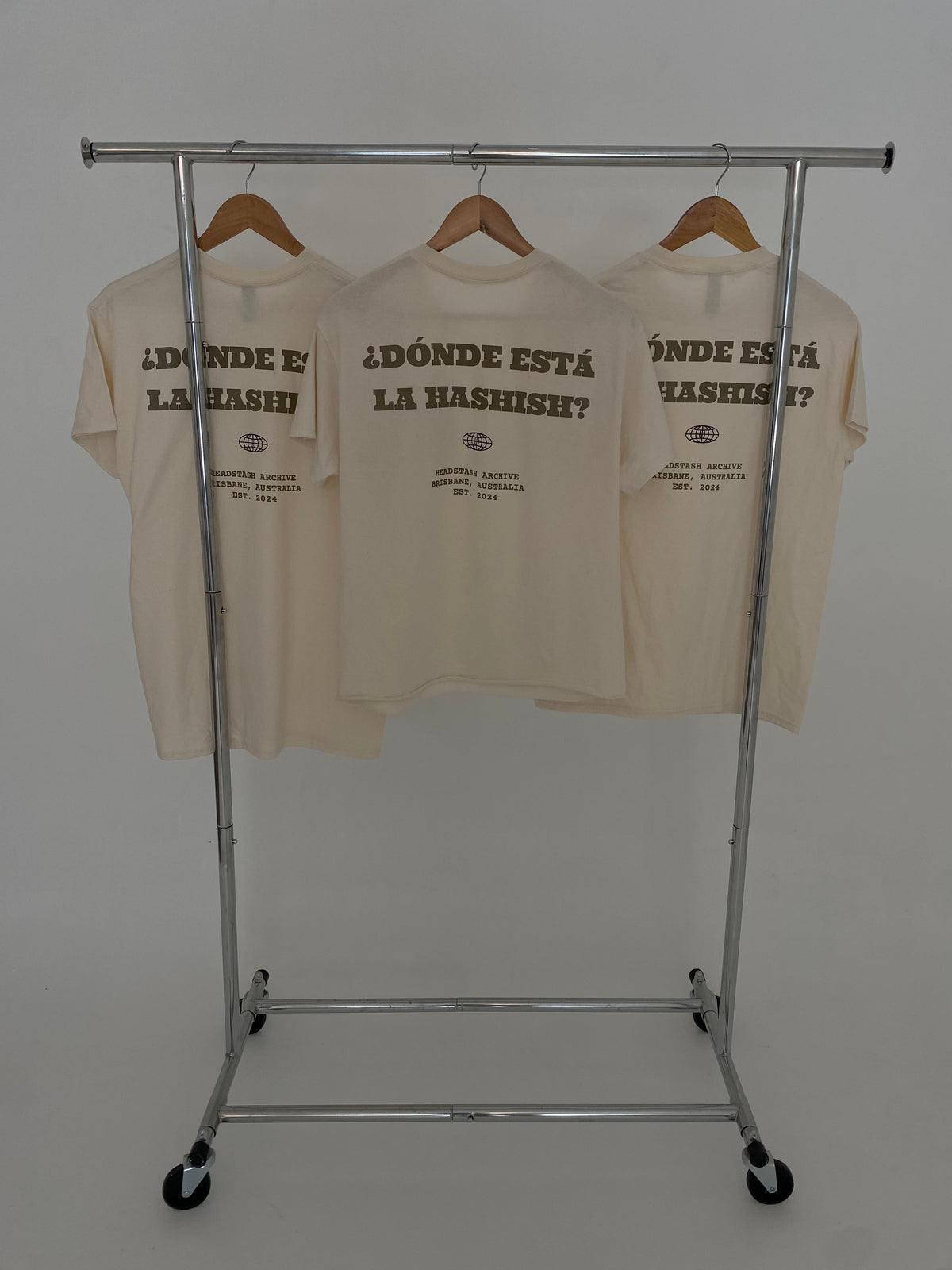 Donde Esta La? Tee — three cream tees on rack