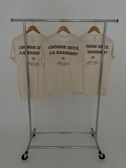 Donde Esta La? Tee — three cream tees on rack